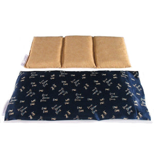 A therapy wrap with a navy blue satin cover. The cover has various chess pieces on it. Behind the wrap is a cotton insert. The insert is sewn into three sections. The insert has a gold color cover.