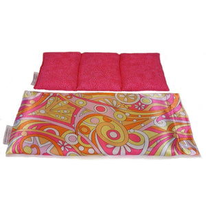 A heating pad with a hippie style pink, orange and yellow satin cover. Behind the heating pad is a cotton insert. The insert is sewn in three individual sections. The cotton insert has a pink cover.