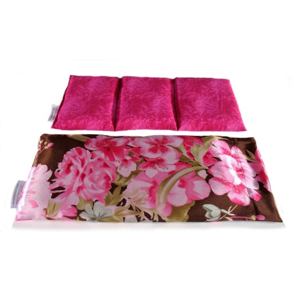 A therapy wrap with a pink and white floral print cover. Behind the wrap is a cotton insert. The insert is sewn in three separate sections. The insert has a pink cover.