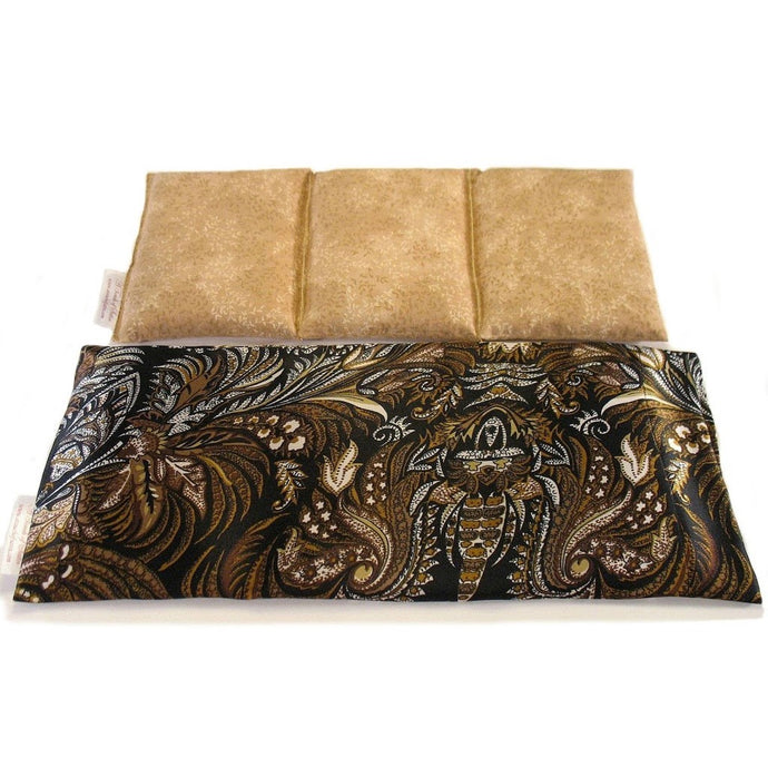 A heating pad with a black, gold and beige paisley satin cover. Behind the heating pad is a cotton insert. The insert is sewn in three sections to keep the flaxseed in place. The insert cover is a mute gold color.