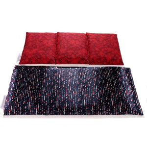 A heat wrap with a red, white and blue satin cover. Behind the wrap is a cotton insert. The insert is sewn in three sections to keep the organic flaxseed in place. The cover of the insert is a reddish rust color.