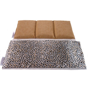 A heating pad with a black, beige and gray dots satin cover. Behind the pad is a cotton insert. The insert is sewn in three sections. This will keep the organic flaxseed in place. The insert has a muted gold color.